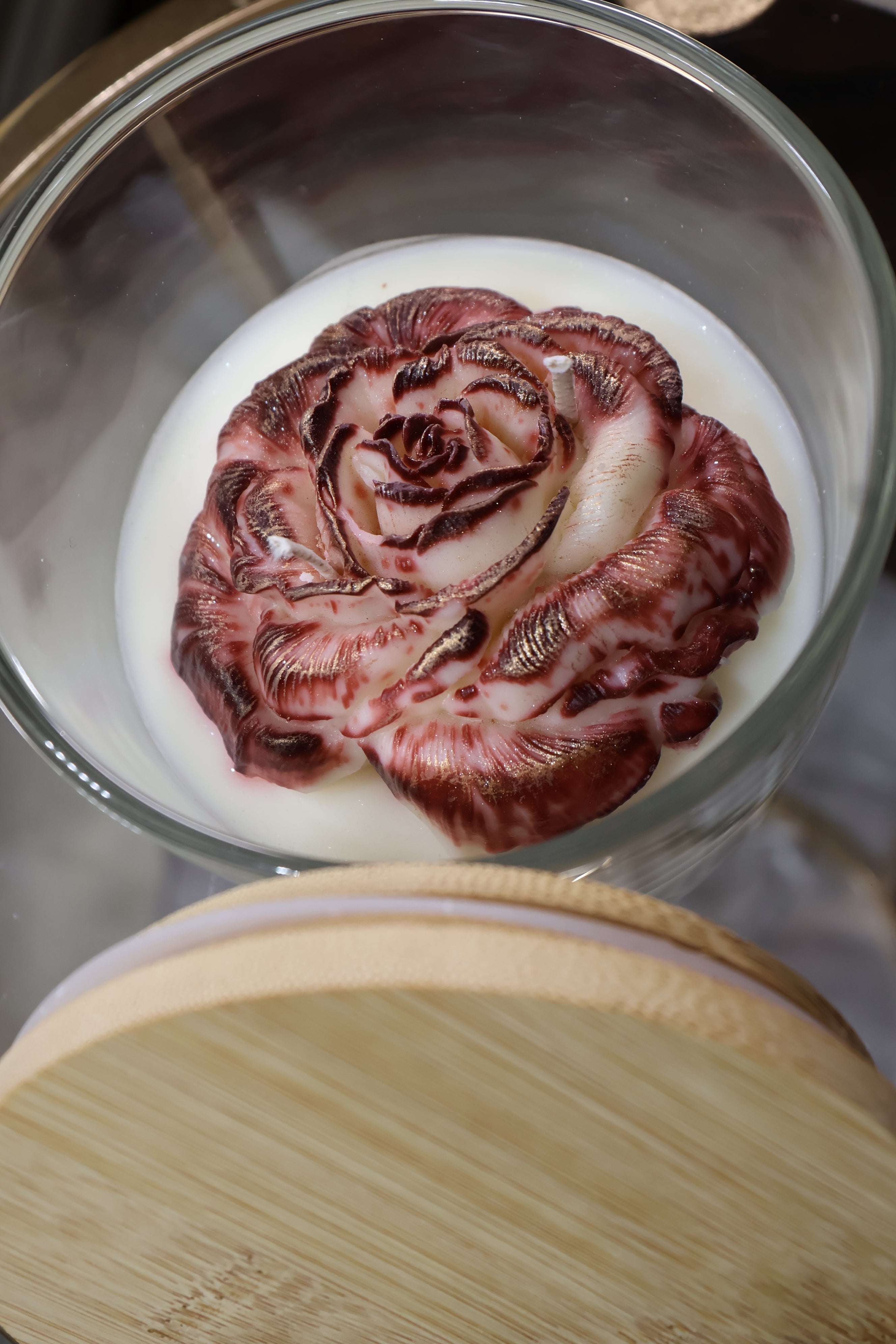 Handcrafted crimson veil rose candle with deep red sculpted wax petals in a glass jar