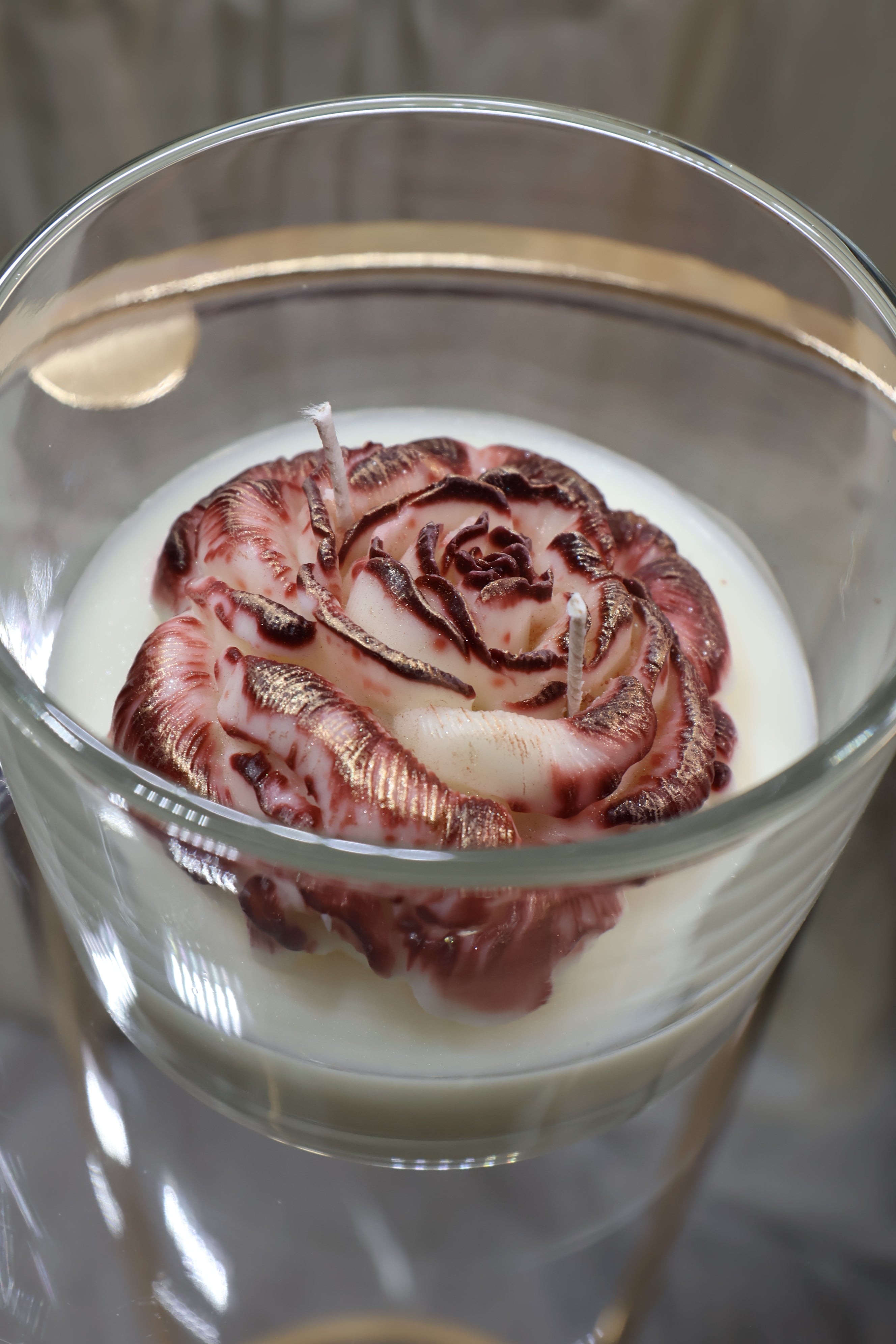 Handcrafted crimson veil rose candle with deep red sculpted wax petals in a glass jar