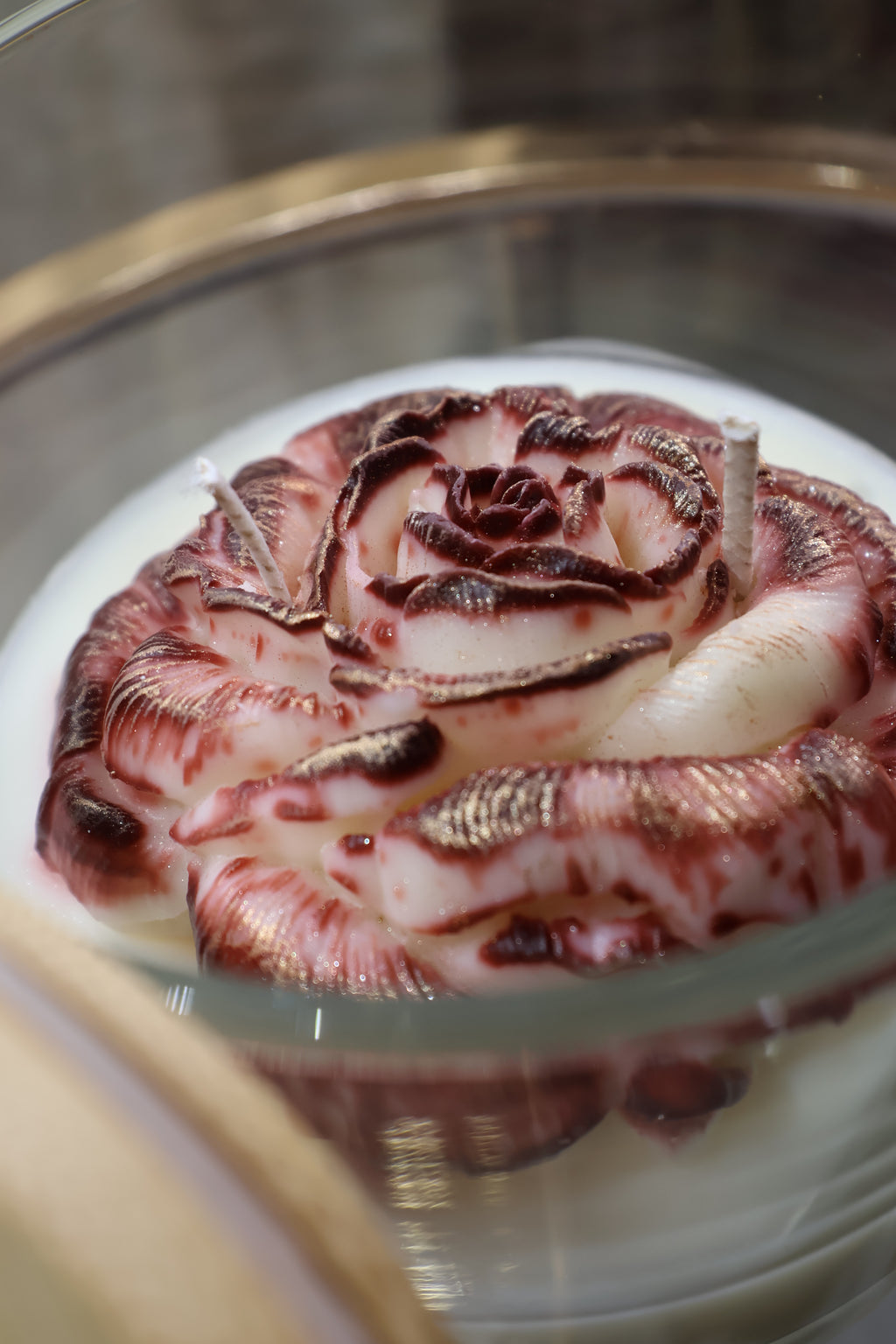 Handcrafted crimson veil rose candle with deep red sculpted wax petals in a glass jar